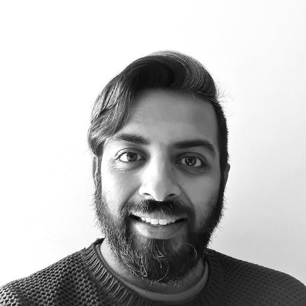 Black and white headshot of Abbas Lokat smiling facing forward set against a white background.