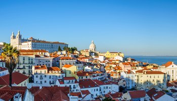A panoramic view of Lisbon, Portugal, showcasing its iconic architecture and vibrant cityscape under a clear blue sky.