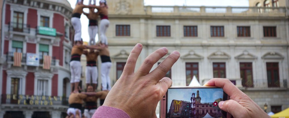 Hand held smartphone taking a picture of Castells Performance