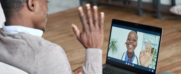 Male african patient on conference video call with female online doctor.