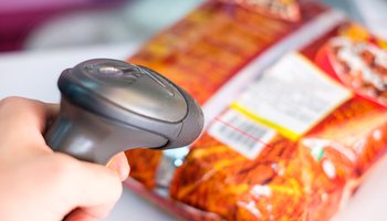 Hand using manual scanner bar code with scan price label