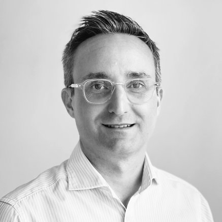 Black and white headshot of Jonathan Worrellsmiling facing forward set against a white background.