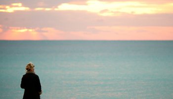 person look out over sea and sunset