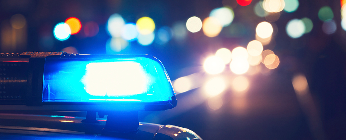 Blurred image of a blue light on top of a police car