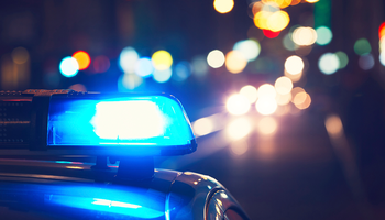 Blurred image of a blue light on top of a police car