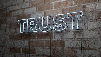 TRUST - Glowing Neon Sign on stonework wall