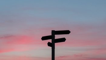 Signpost against sunset