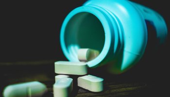 Pill/capsules spilling out of a pot