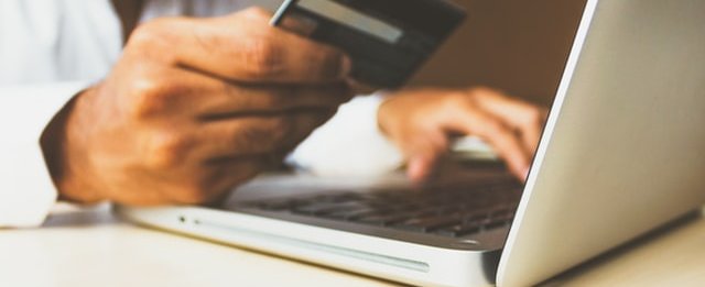 Man's hand with credit card and laptop computer