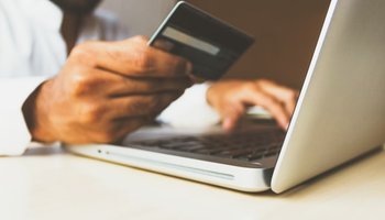 Man's hand with credit card and laptop computer